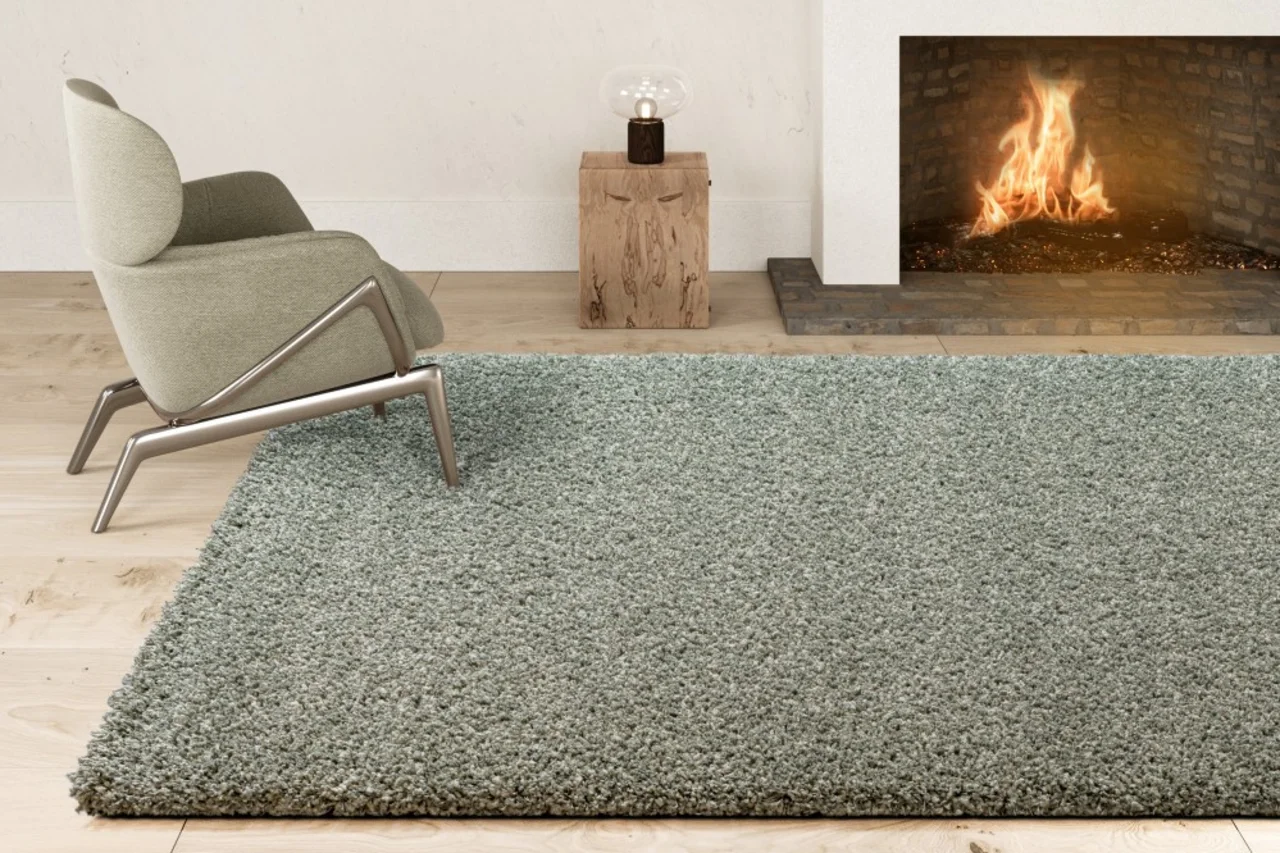 Ein Hochflor Teppich liegt im Wohnzimmer vor dem Kamin - Ein Hochflor Teppich liegt im Wohnzimmer vor dem Kamin